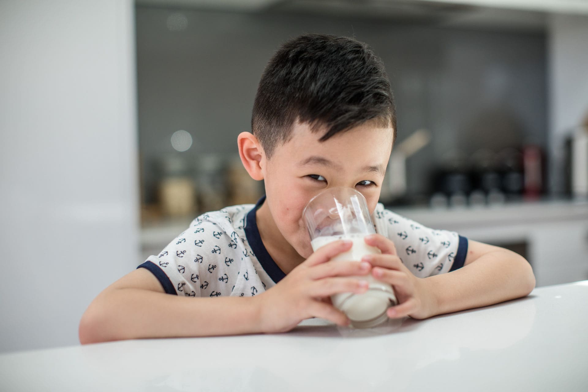 Young boy drinking milk from glass